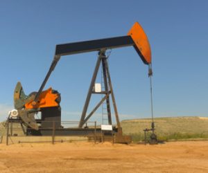 Industrial jack pump platform pumping crude oil in Texas desert